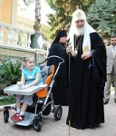 Святейший Патриарх Кирилл благословил девочку, страдающую детским церебральным параличом, и подарил ей специальную коляску для детей с ограниченными возможностями