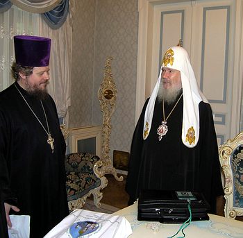  Святейший Патриарх Алексий II  получает от руководителя аппарата Секретариата Архиерейского Собора протоиерея Сергия Киселева пакет с документами